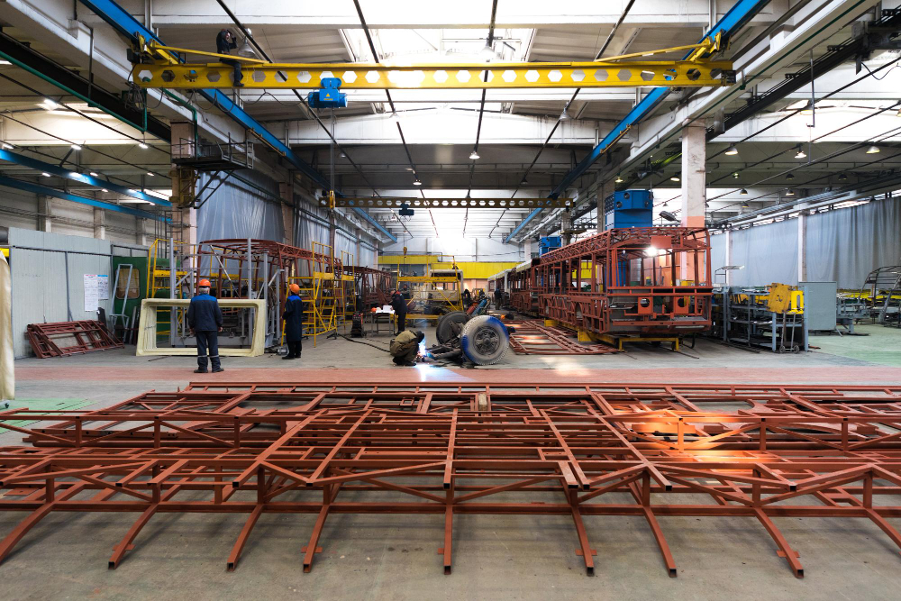 one-working-day-modern-automatic-bus-trolleybus-car-production-with-unfinished-cars-workers-protective-uniform-factory-background-automobile-assembly-line-welding-arm